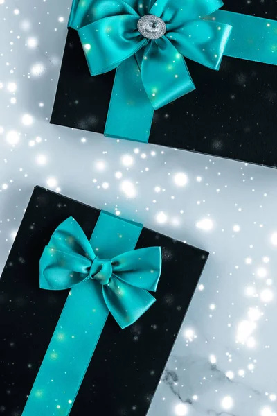 Zimní prázdninové dary se smaragdovou hedvábnou maší a zářící sníh na f — Stock fotografie