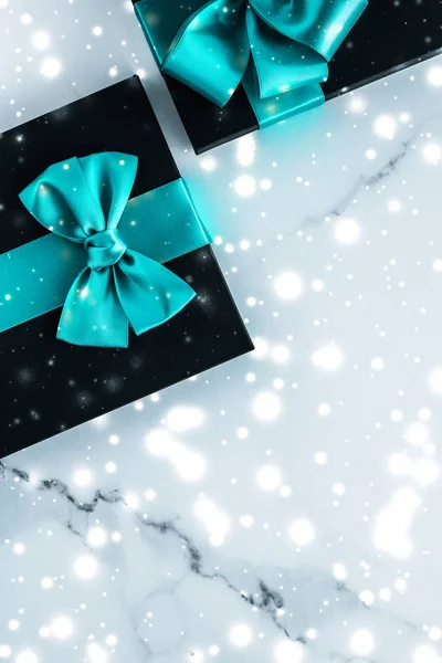 Winter holiday gifts with emerald silk bow and glowing snow on f — Stock Photo, Image