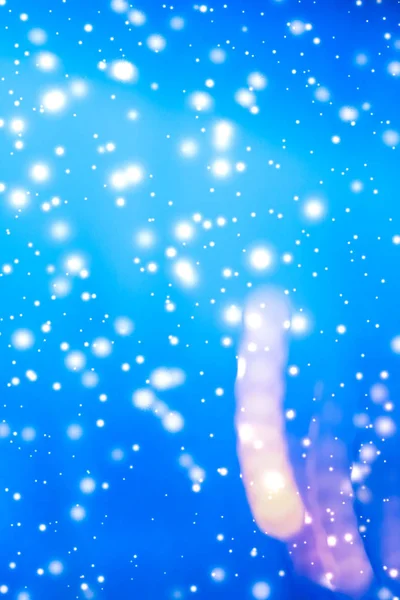 Winter holiday abstract background, glowing snow and magic spark