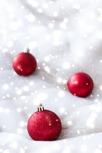 Rote Christbaumkugeln auf flauschigem Fell mit Schneeglitzern, Luxus — Stockfoto