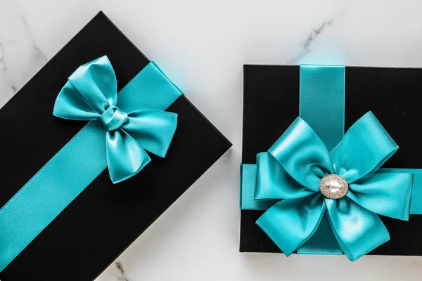 Lyx semester gåvor med smaragd sidenband och rosett på marmor — Stockfoto