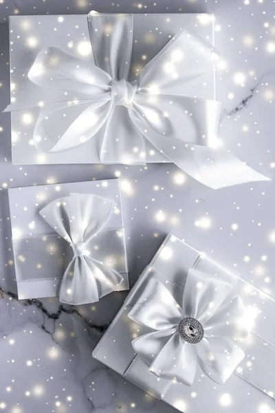Роскошные праздничные подарки с белым шелковым луком и лентами на мраморе b — стоковое фото