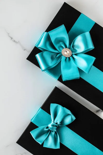 Luxusní sváteční dary se smaragdovou hedvábnou stuhou a lukem na mramoru — Stock fotografie