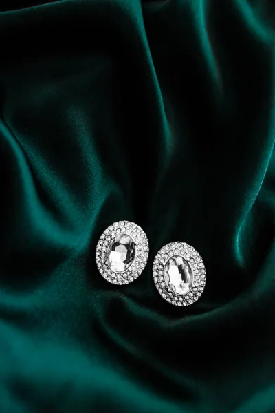 Pendientes de diamantes de lujo en seda verde esmeralda oscura, glamour navideño —  Fotos de Stock