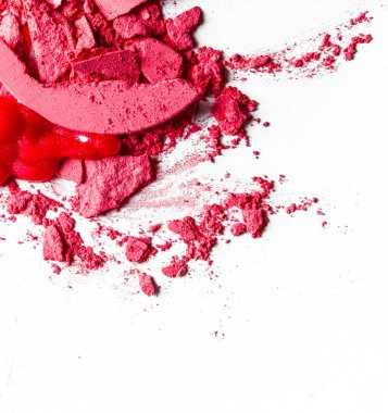 Beyaz arka plan müziği üzerinde yalıtılmış ezilmiş göz farı, ruj ve toz