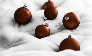 Beyaz kabarık kürk zemin üzerinde Çikolata kahverengi Noel baubles, 