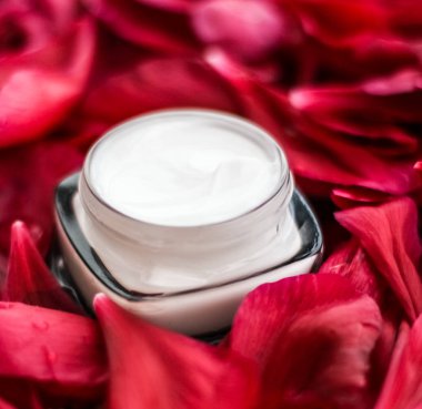 Kırmızı çiçek yaprakları ve WA Hassas Cilt Bakımı nemlendirici krem