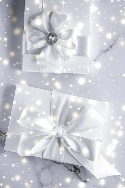 Luxus-Weihnachtsgeschenke mit weißer Seidenschleife und Bändern auf Marmor — Stockfoto