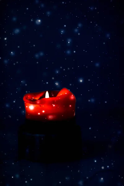 Червона святкова свічка на темному ігристому сніжному фоні, розкіш — стокове фото
