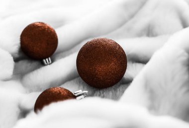 Beyaz kabarık kürk zemin üzerinde Çikolata kahverengi Noel baubles, 
