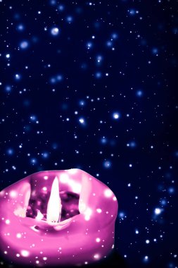 Mavi köpüklü kar arka plan üzerinde pembe tatil mum, lüks