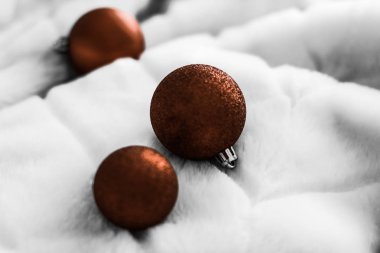 Beyaz kabarık kürk zemin üzerinde Çikolata kahverengi Noel baubles, 