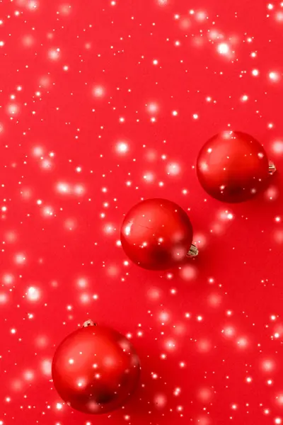 Christbaumkugeln auf rotem Hintergrund mit Schneeglitzern, Luxus — Stockfoto