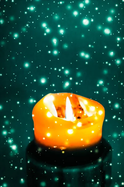 橙色节日蜡烛在绿色闪闪发光的雪背景，勒克斯 — 图库照片