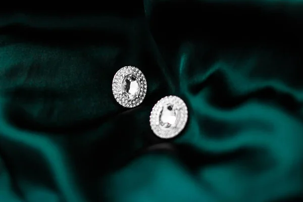 Pendientes de diamantes de lujo en seda verde esmeralda oscura, glamour navideño —  Fotos de Stock