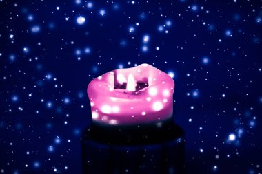 Mavi köpüklü kar arka plan üzerinde pembe tatil mum, lüks