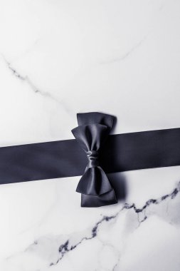 Siyah ipek kurdele ve yay mermer arka planda, yatık