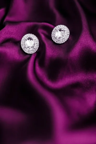 Lyx diamantörhängen på mörkrosa sidentyg, Holiday glamou — Stockfoto
