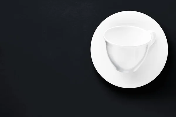 Bílé nádobí z černého nádobí, prázdný pohár na pozadí černé roviny — Stock fotografie