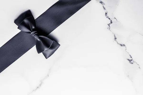 Nastro di seta nera e fiocco su sfondo marmo, flatlay — Foto Stock