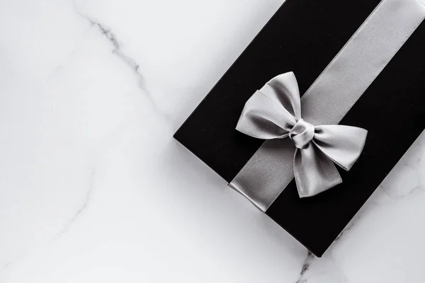 Розкішні святкові подарунки зі срібною шовковою стрічкою та бантом на мармурі b — стокове фото