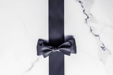 Siyah ipek kurdele ve yay mermer arka planda, yatık