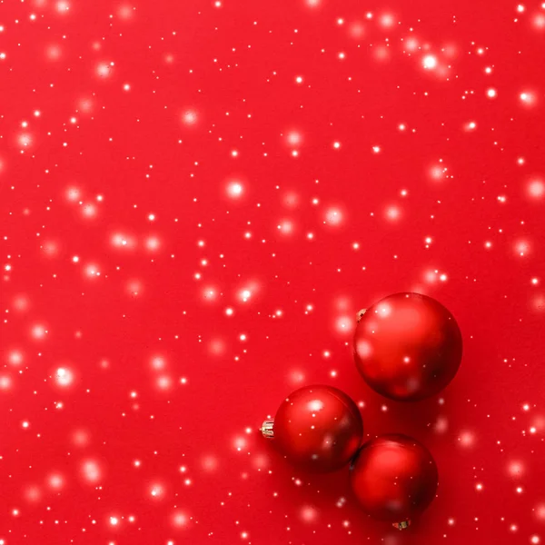 Julgranskulor på röd bakgrund med snöglitter, lyx Wi — Stockfoto