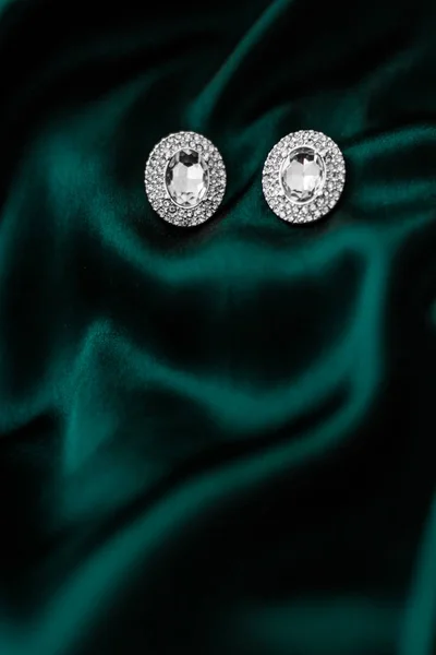 Lyxiga diamantörhängen på mörkt smaragdgrönt siden, Holiday Glam — Stockfoto