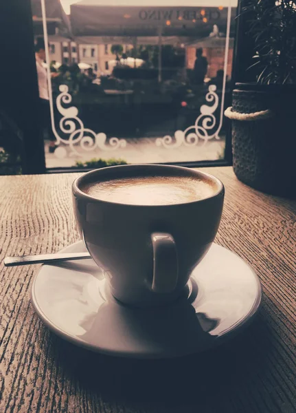 Xícara de cappuccino quente em uma cafetaria, café em uma mesa de madeira i — Fotografia de Stock