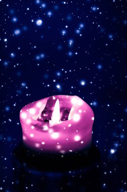 Mavi köpüklü kar arka plan üzerinde pembe tatil mum, lüks