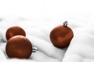 Beyaz kabarık kürk zemin üzerinde Çikolata kahverengi Noel baubles, 