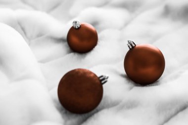 Beyaz kabarık kürk zemin üzerinde Çikolata kahverengi Noel baubles, 