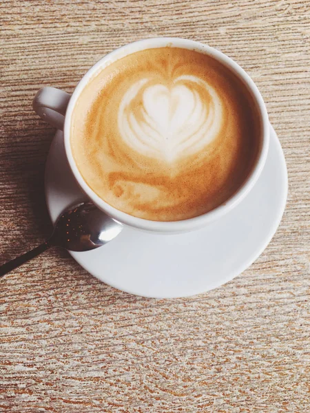 Tasse de cappuccino chaud dans une cafétéria, café sur une table en bois i — Photo