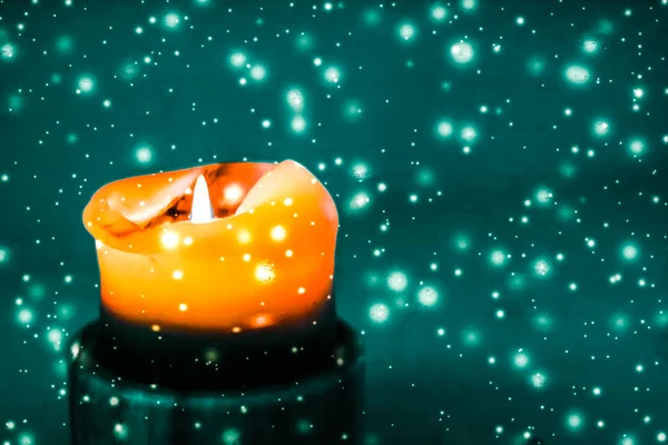 Pomarańczowa świeca świąteczną na zielonym, błyszczącym tle śniegu, Lux — Zdjęcie stockowe