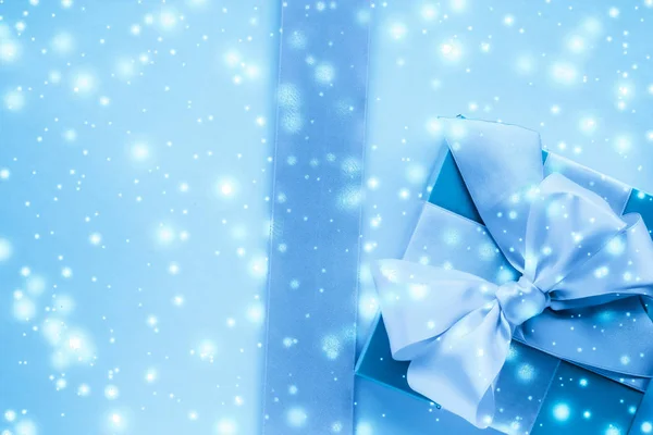 Зимний праздник подарки и светящийся снег на замерзшем голубом фоне , — стоковое фото