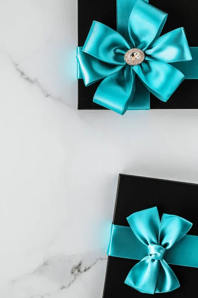 Regalos de lujo con cinta de seda esmeralda y lazo en mármol — Foto de Stock