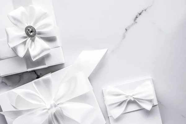 Luxury wedding gifts with silk bow and ribbons on marble backgro