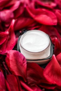 Kırmızı çiçek yaprakları ve WA Hassas Cilt Bakımı nemlendirici krem