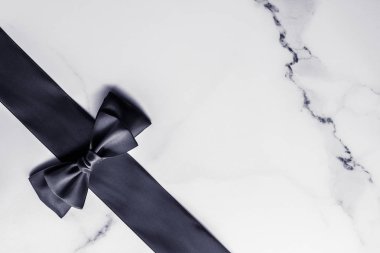 Siyah ipek kurdele ve yay mermer arka planda, yatık