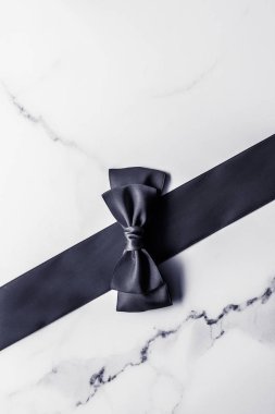 Siyah ipek kurdele ve yay mermer arka planda, yatık