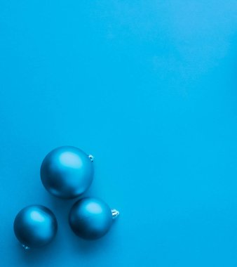 Mavi flatlay fon üzerinde Noel baubles, lüks kış holida