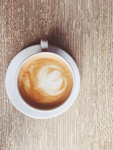 Tasse de cappuccino chaud dans une cafétéria, café sur une table en bois i — Photo