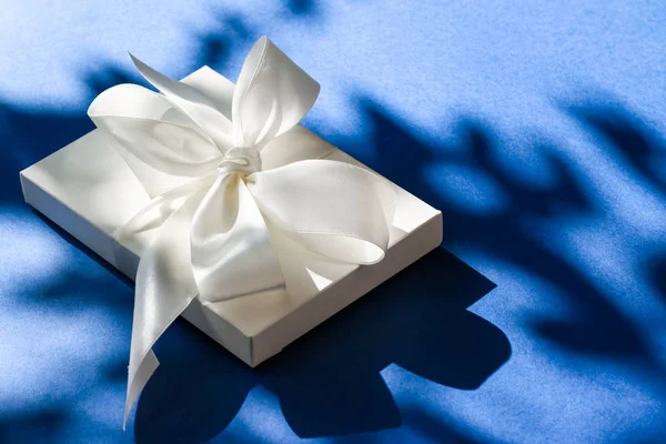 Πολυτελές λευκό κουτί δώρων με μεταξωτή κορδέλα και φιόγκο στο μπλε b — Φωτογραφία Αρχείου