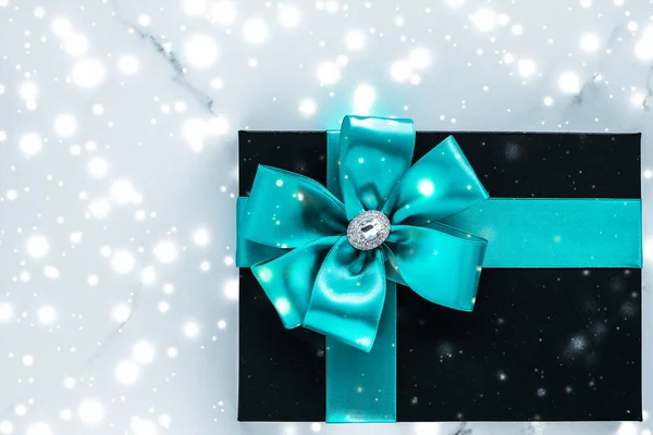 Zimní prázdninové dary se smaragdovou hedvábnou maší a zářící sníh na f — Stock fotografie