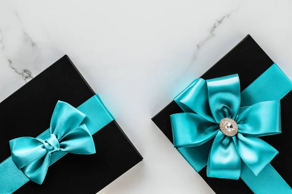 Luxury holiday gifts with emerald silk ribbon and bow on marble — Stock Photo, Image