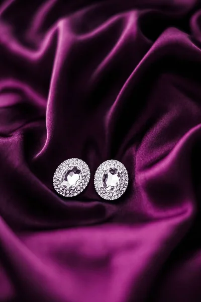 Pendientes de diamantes de lujo en tela de seda rosa oscuro, glamou de vacaciones —  Fotos de Stock