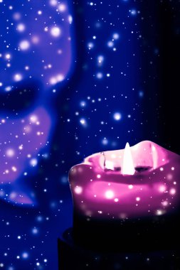 Mavi köpüklü kar arka plan üzerinde pembe tatil mum, lüks