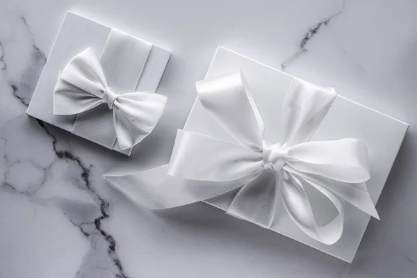 Luxury wedding gifts with silk bow and ribbons on marble backgro — Stock Photo, Image