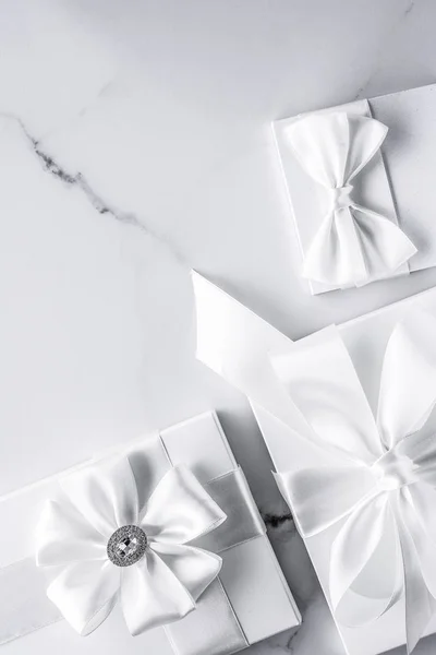 Luxury wedding gifts with silk bow and ribbons on marble backgro