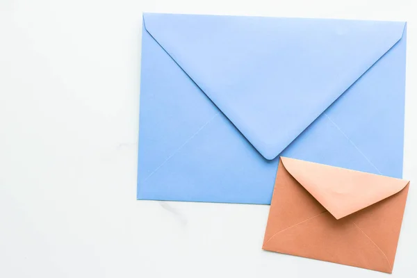 Buste di carta bianca su sfondo flatlay di marmo, posta festiva — Foto Stock